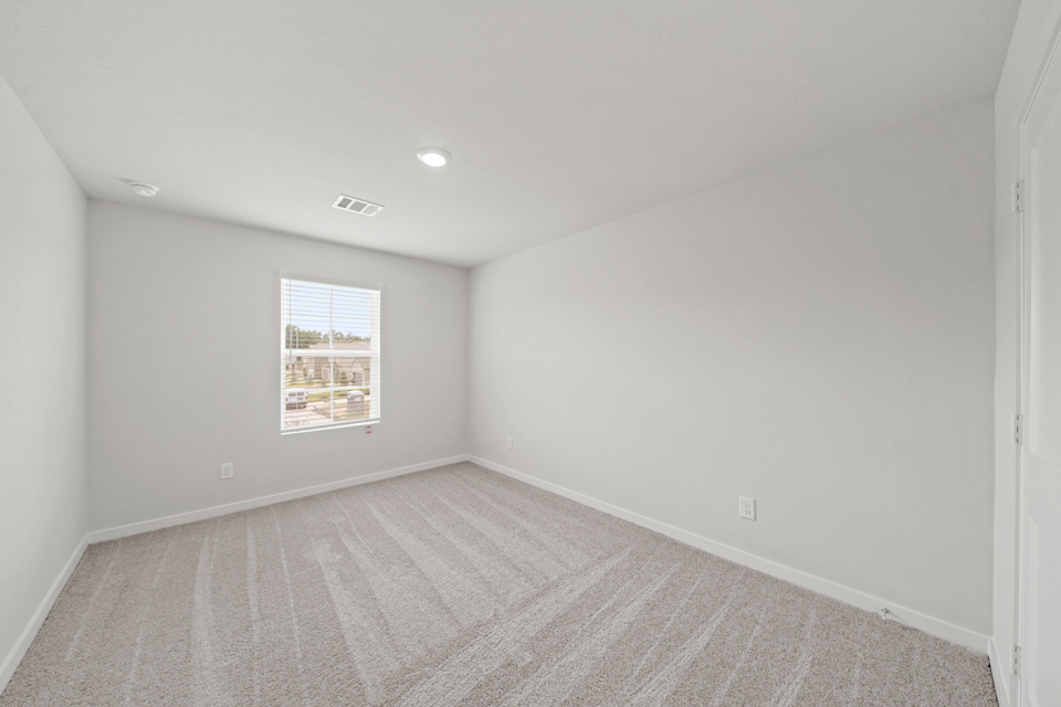 A room with a carpet and a window.