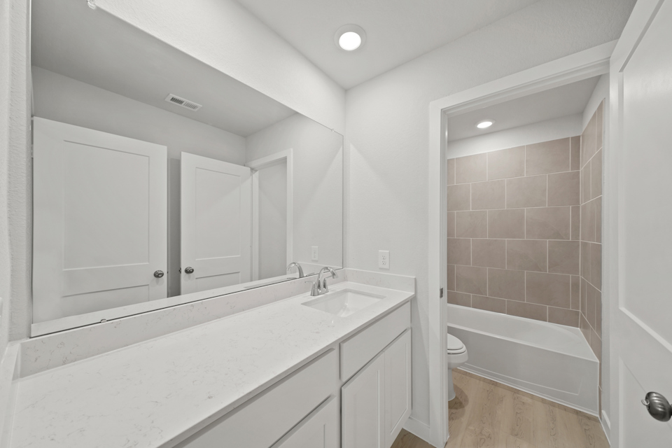 A bathroom with a tub sink and toilet.