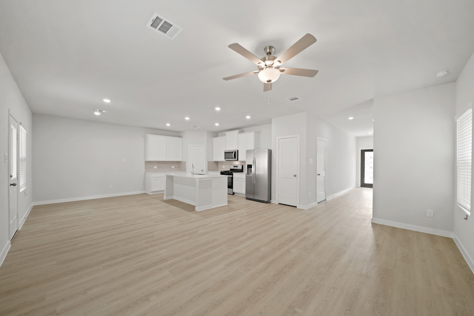 A large kitchen with a wood floor.