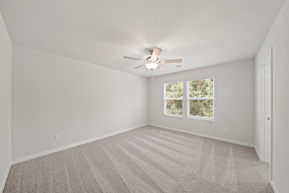 A room with a ceiling fan and a window.