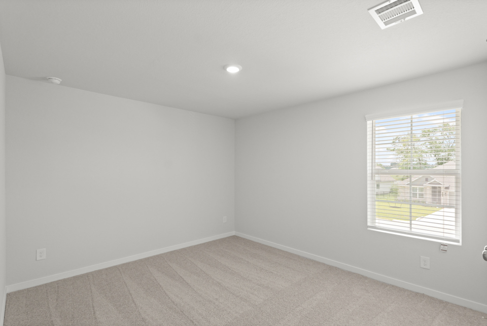 A room with a window and a carpet.