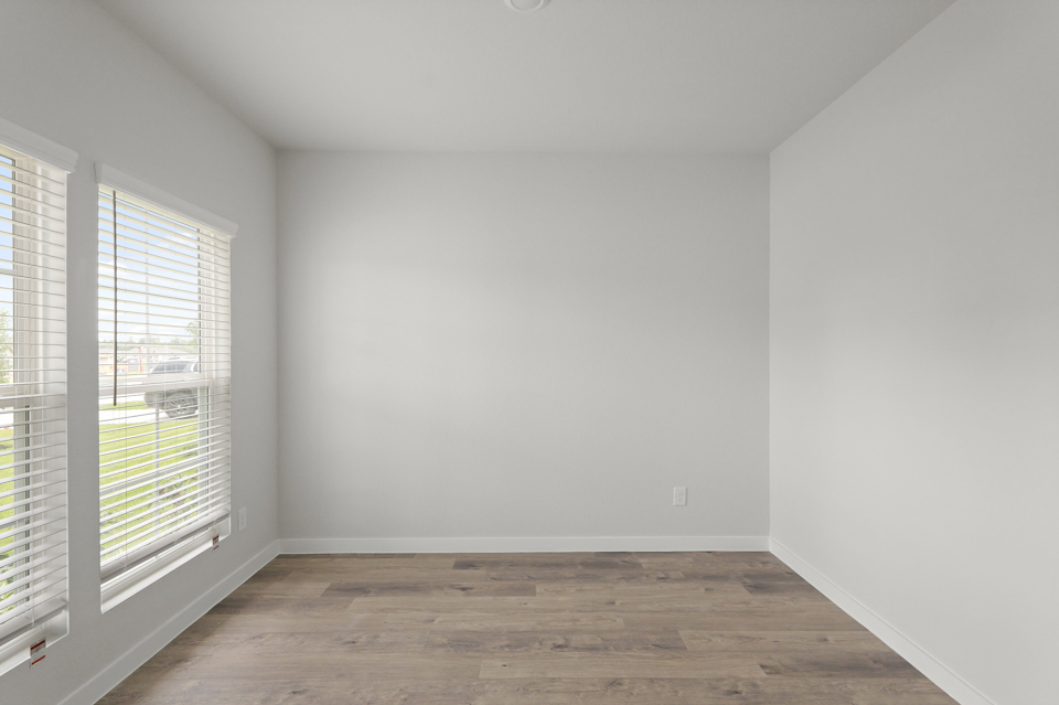 A room with a wood floor and windows.