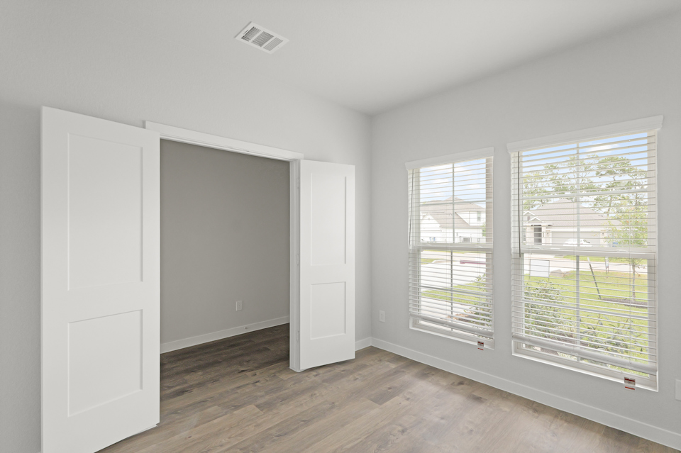 A room with windows and a wood floor.