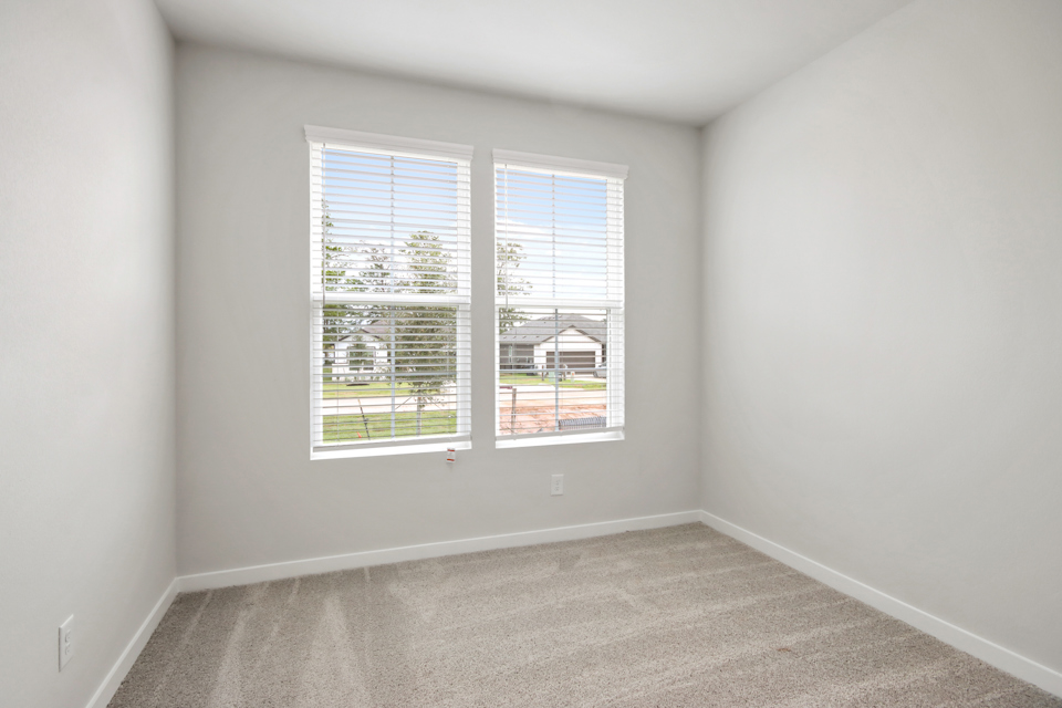 A room with a window and a carpet.