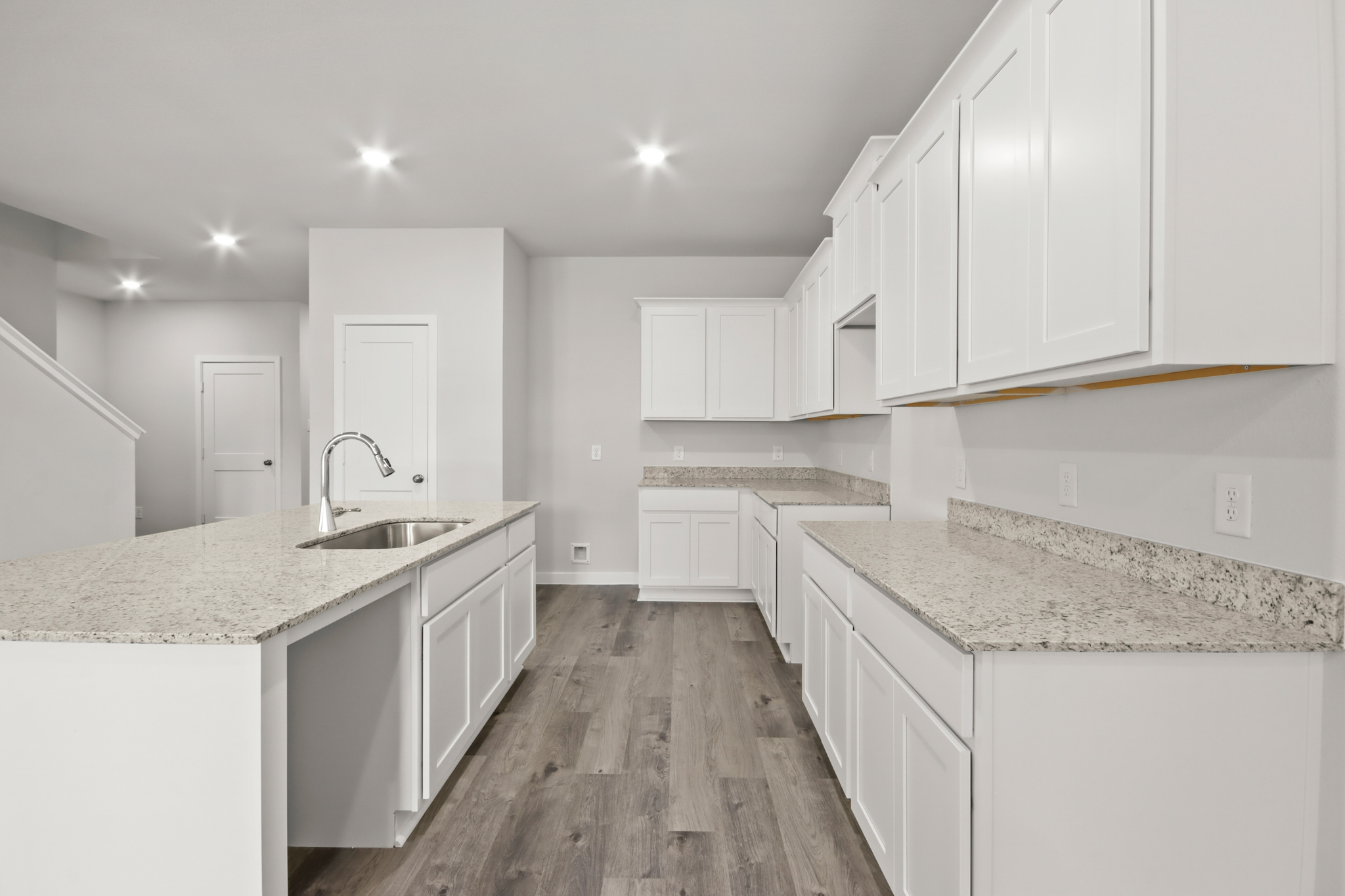 A kitchen with white cabinets.