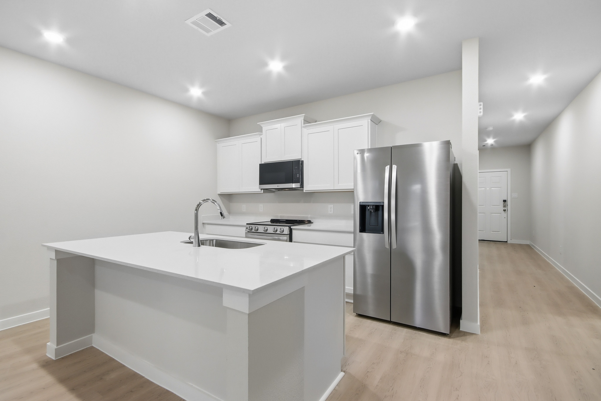A kitchen with white cabinets.