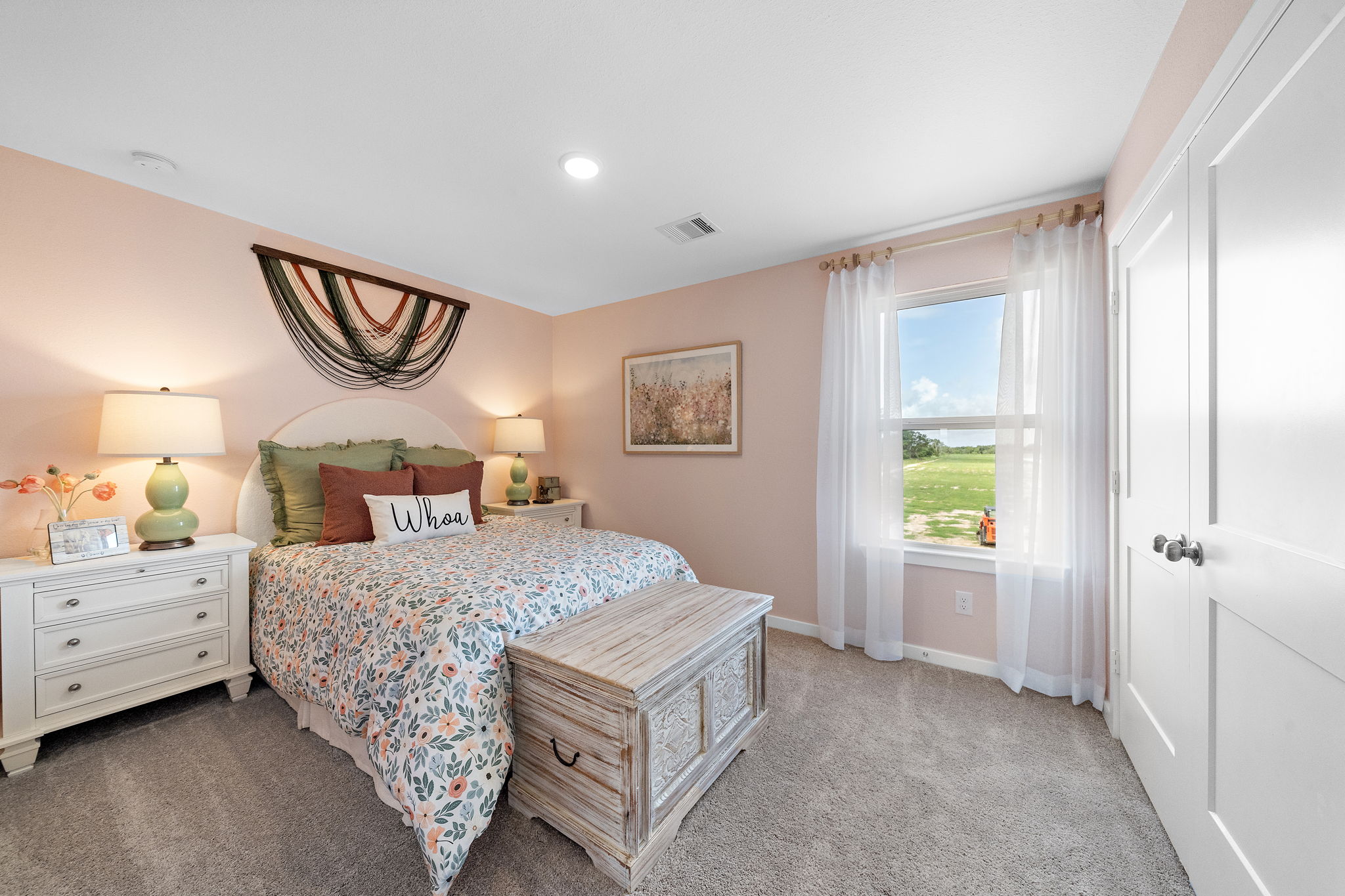 A bedroom with a bed and a dresser.