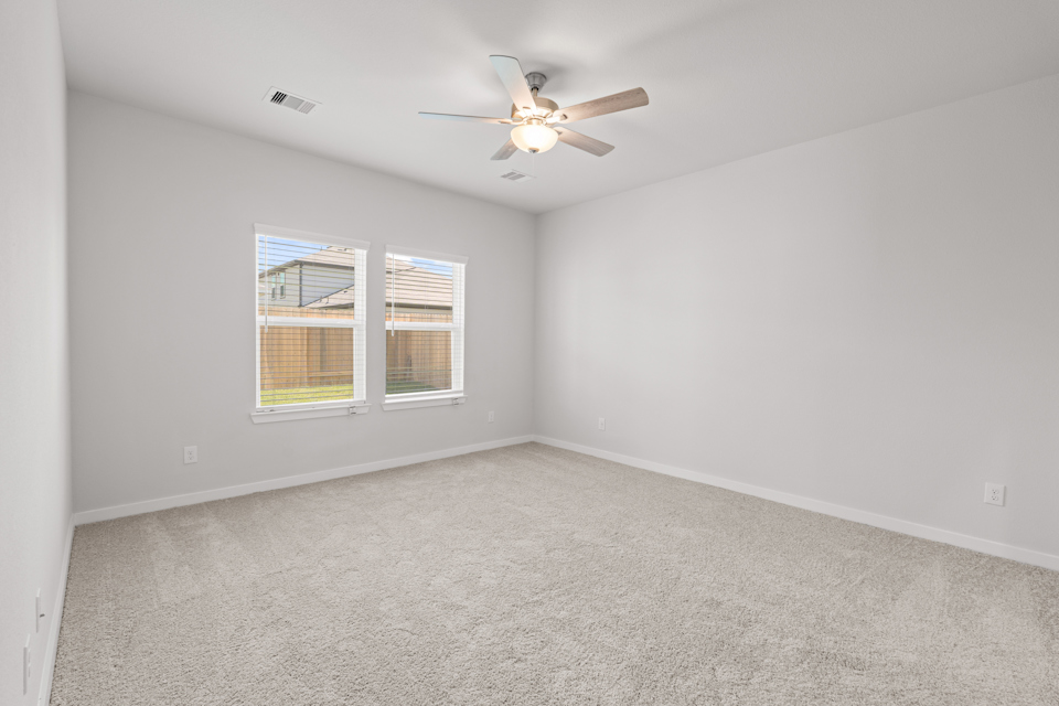 A room with a ceiling fan and a window.