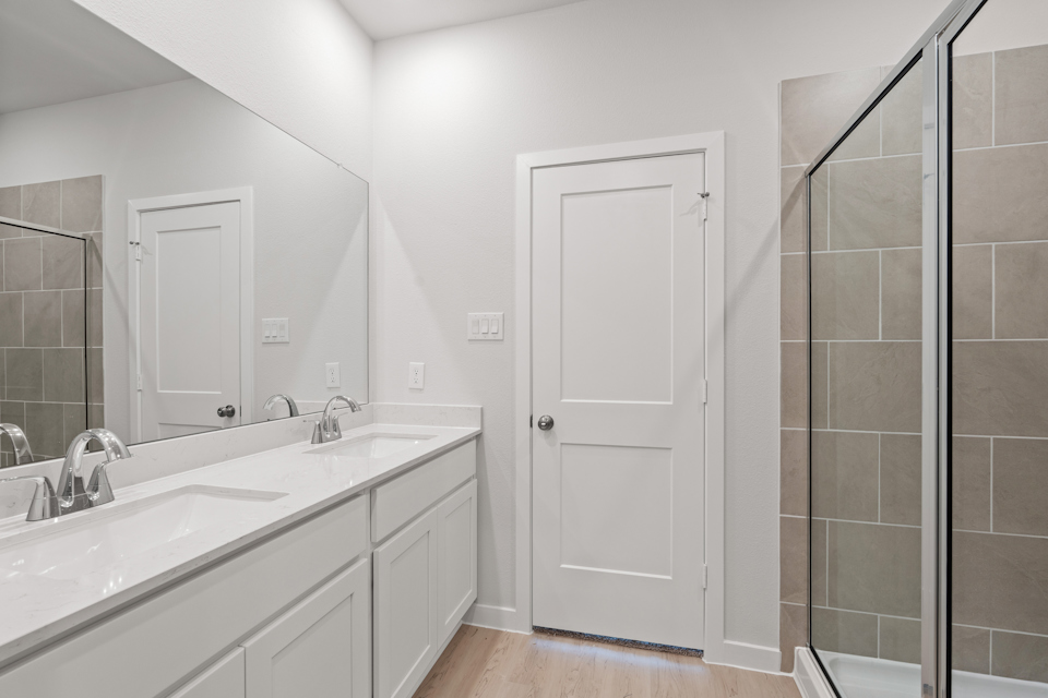 A bathroom with a sink and a shower unit.