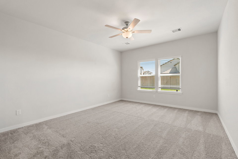 A room with a ceiling fan and a window.