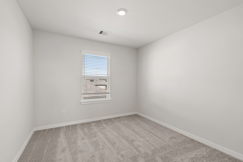 A room with a window and a carpet.