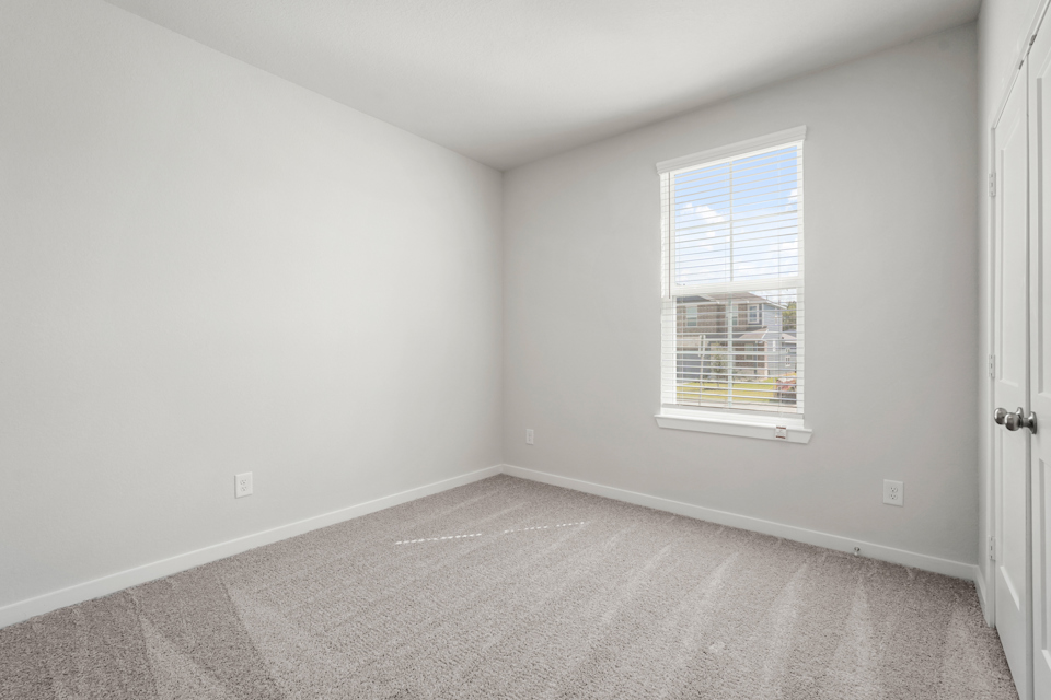 A room with a window and a carpet.