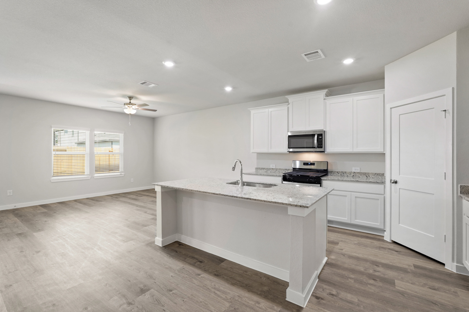 A kitchen with white cabinets.