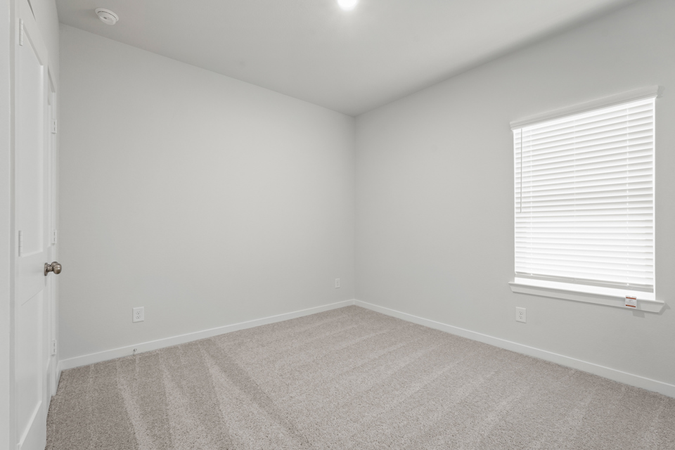 A room with a carpet and a window.