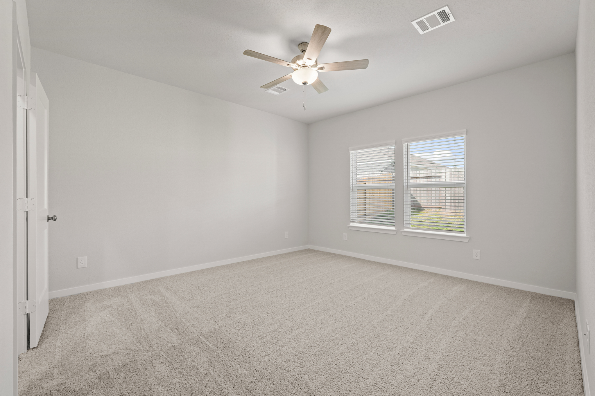 A room with a ceiling fan and a window.