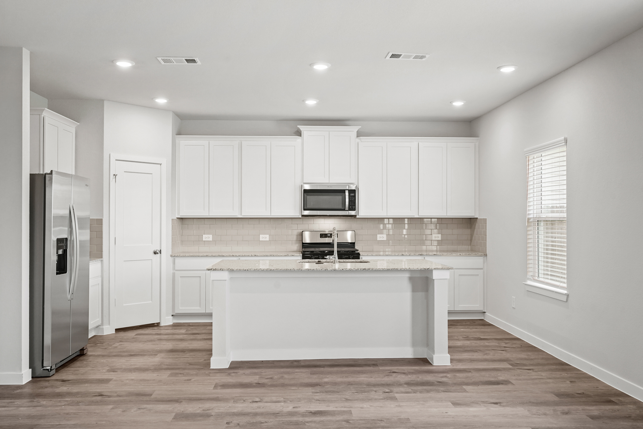 A kitchen with white cabinets.