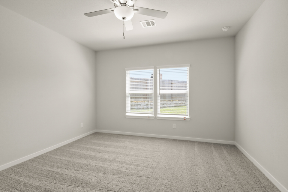 A room with a ceiling fan and a window.