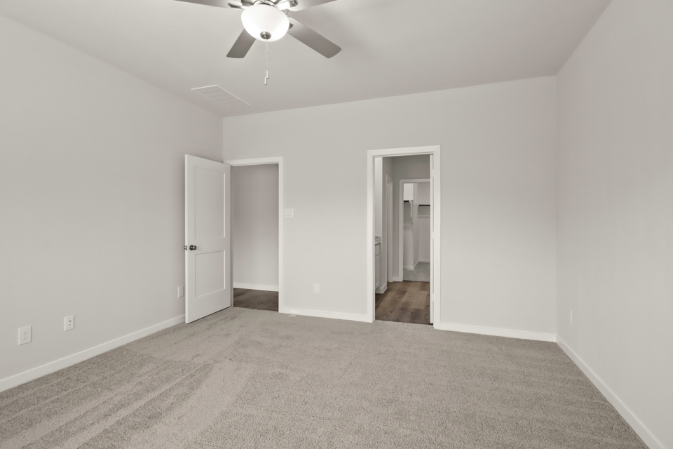 A room with a ceiling fan and a door.
