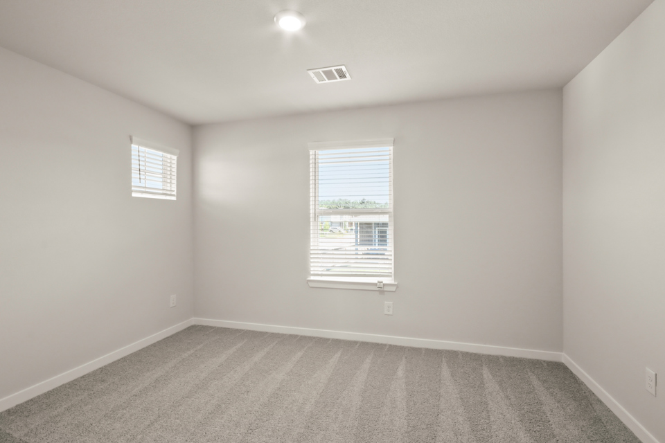 A room with a window and a carpet.