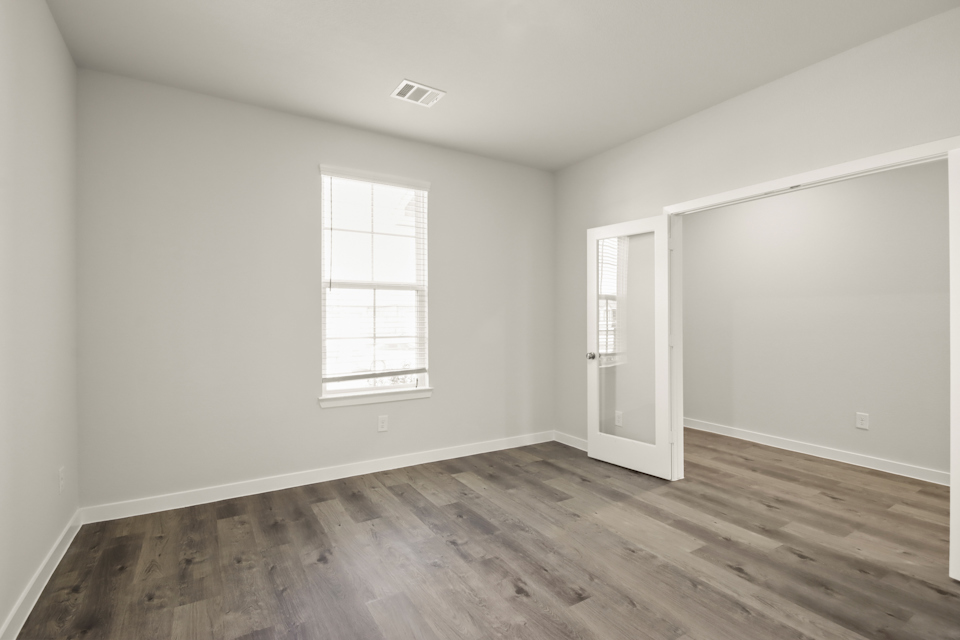 A room with a wood floor and a window.