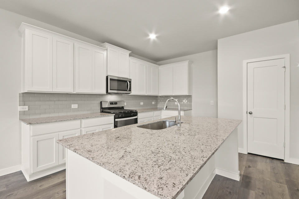 A kitchen with white cabinets.