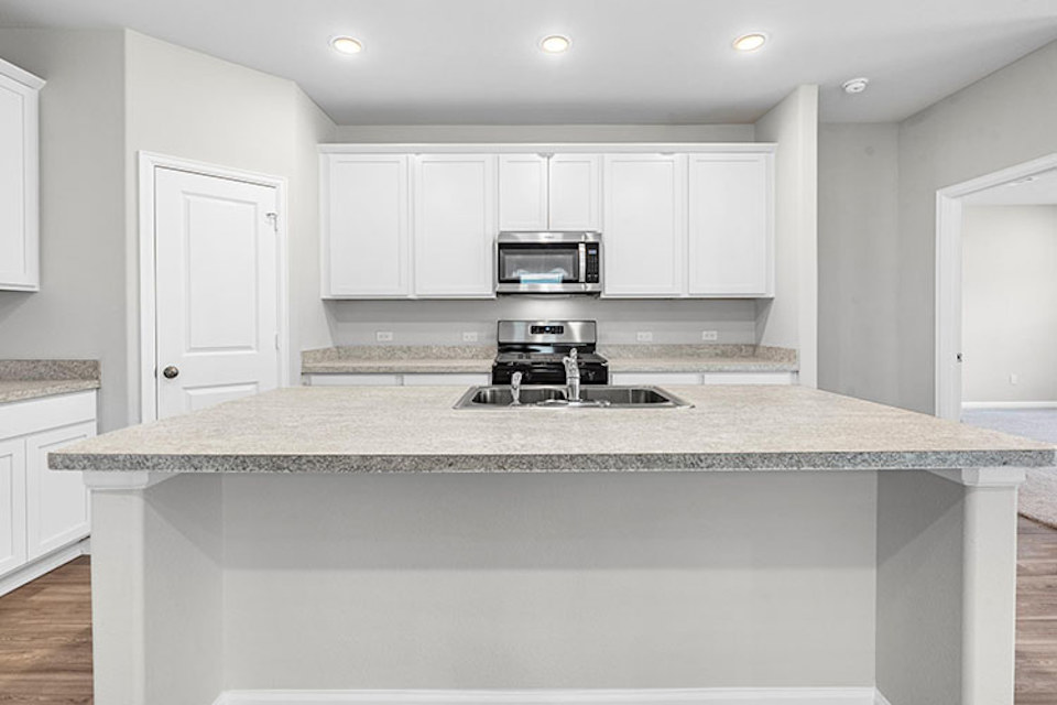 A kitchen with white cabinets.