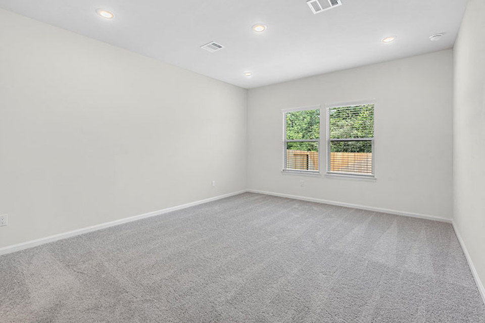 A room with a carpet and windows.