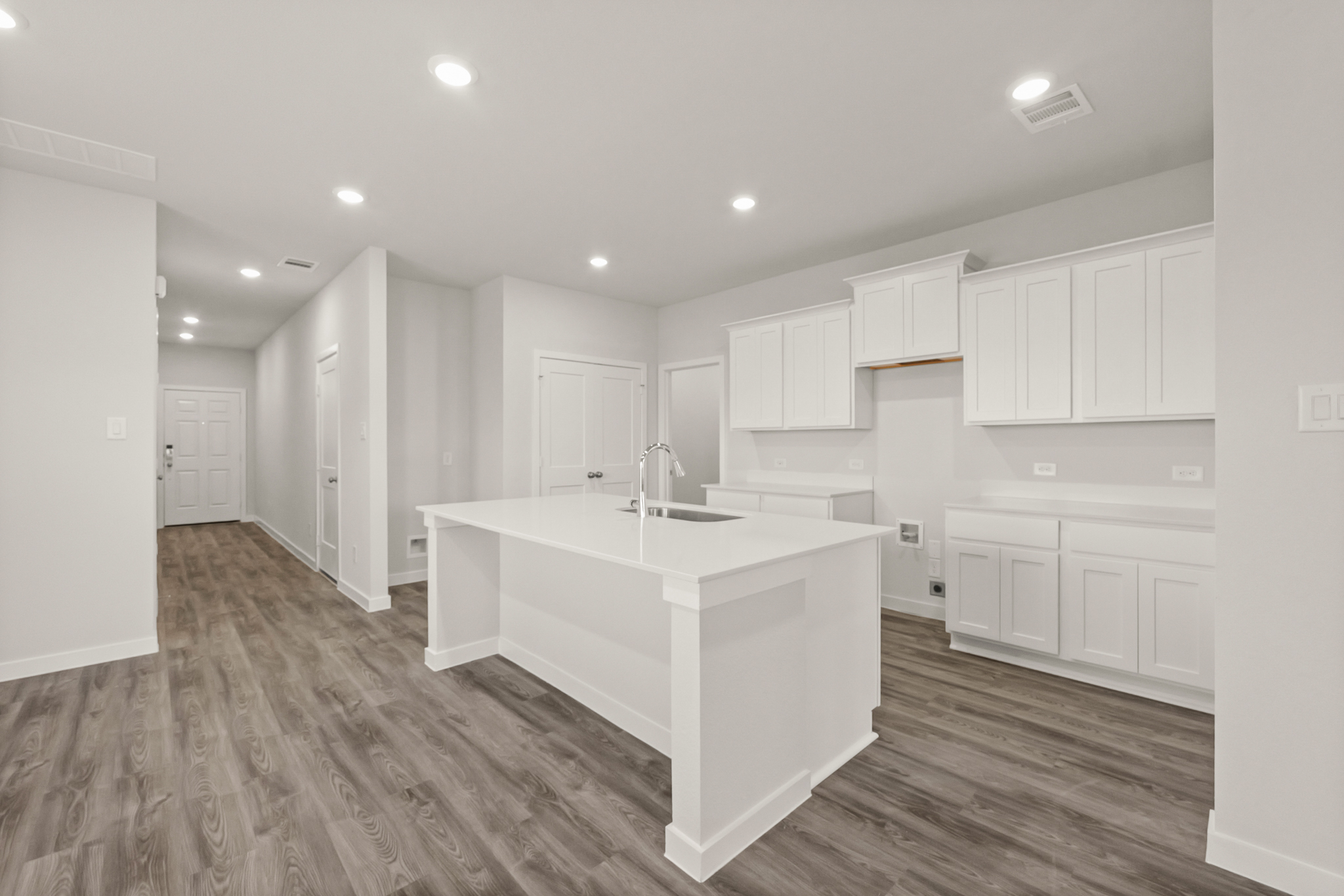 A kitchen with white cabinets.