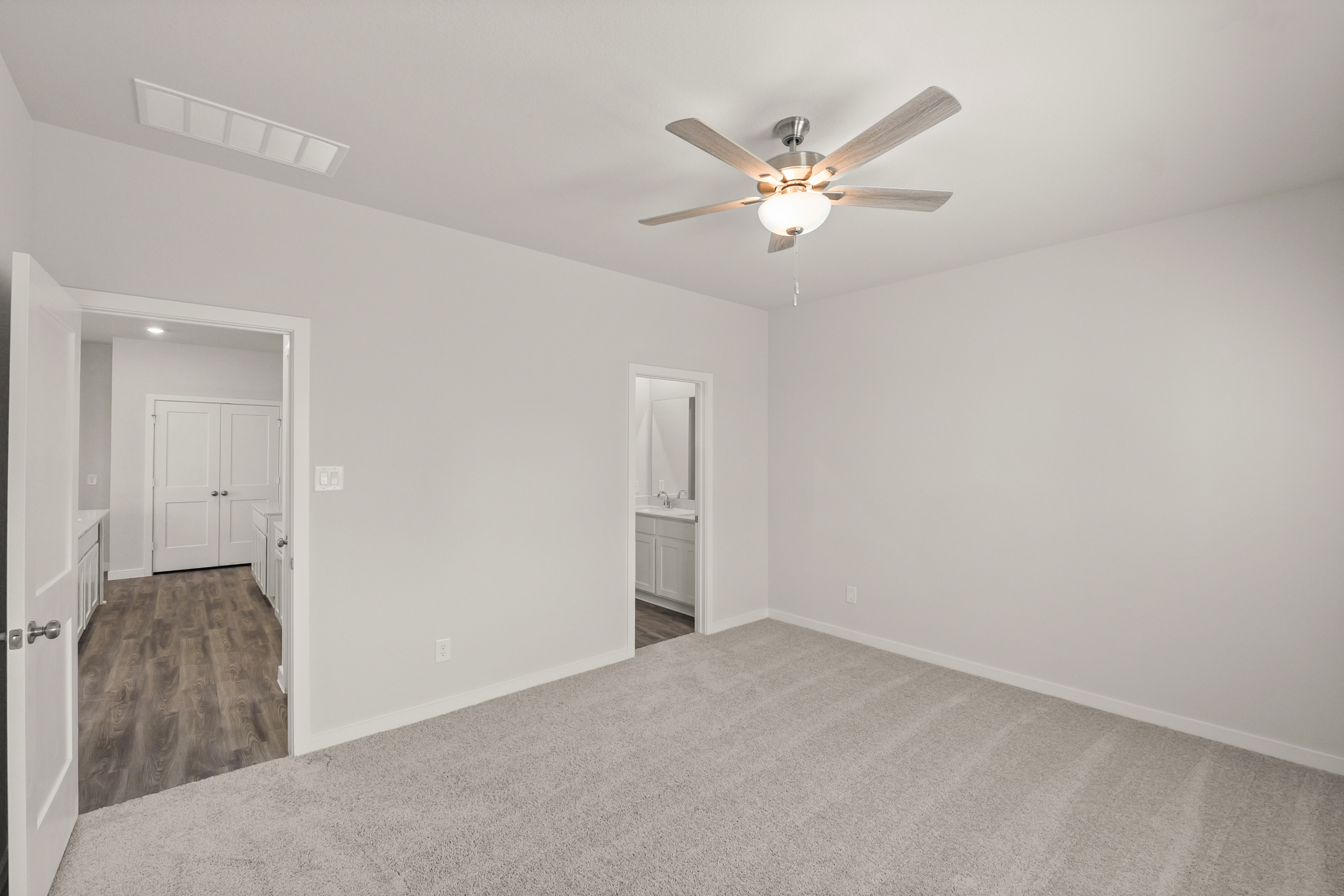 A room with a ceiling fan and a door.