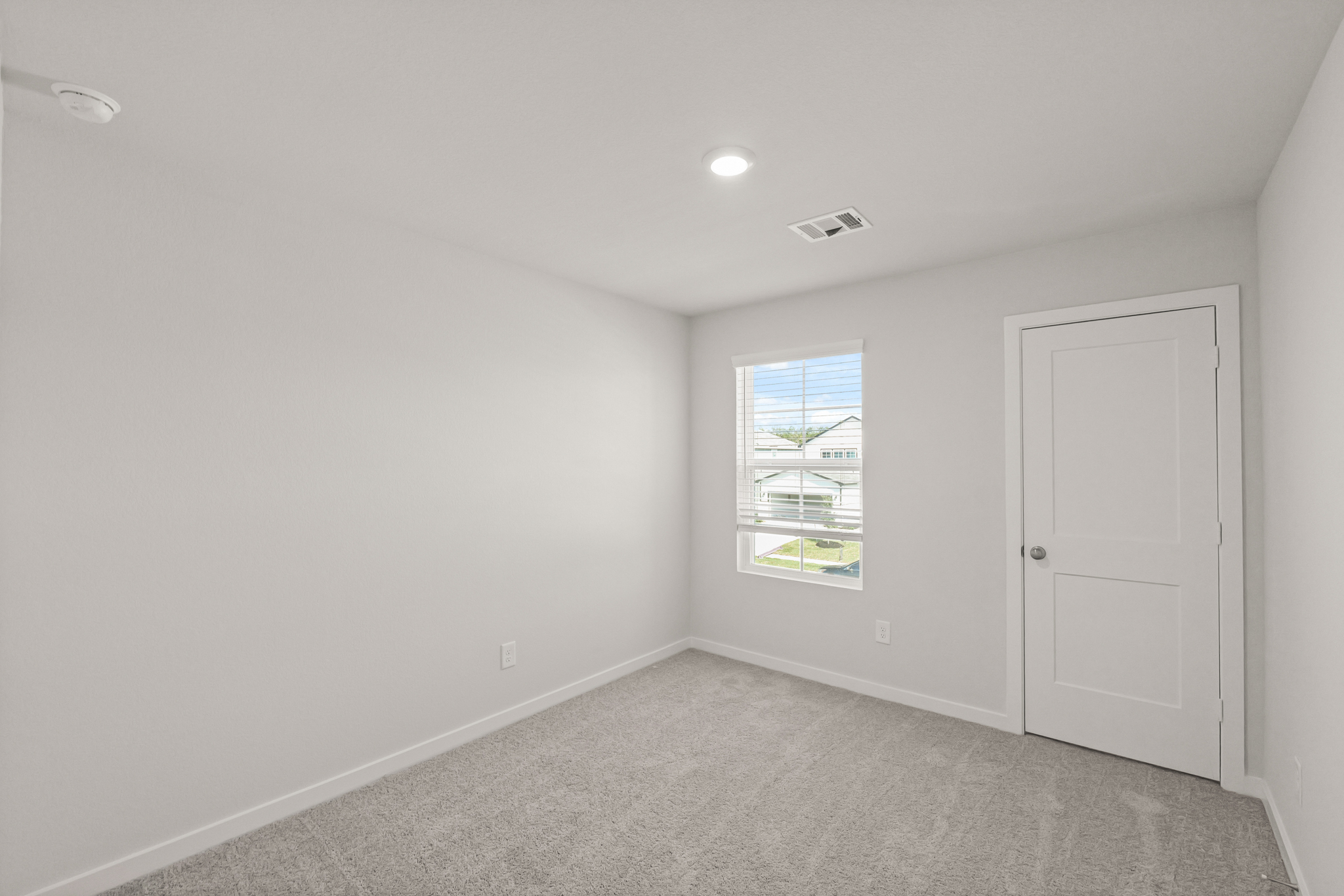 A room with white walls and a window.
