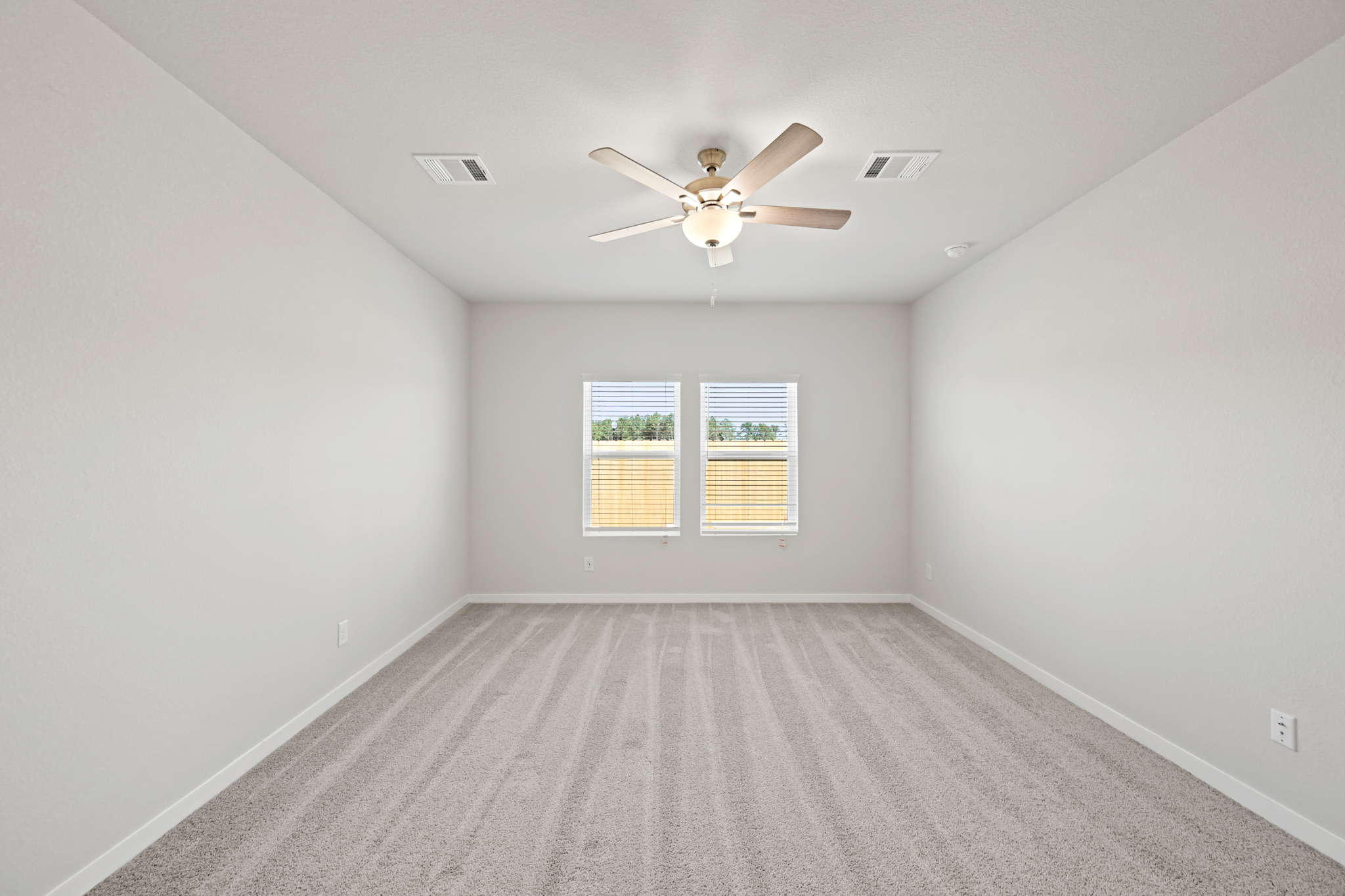 A room with a ceiling fan and a window.