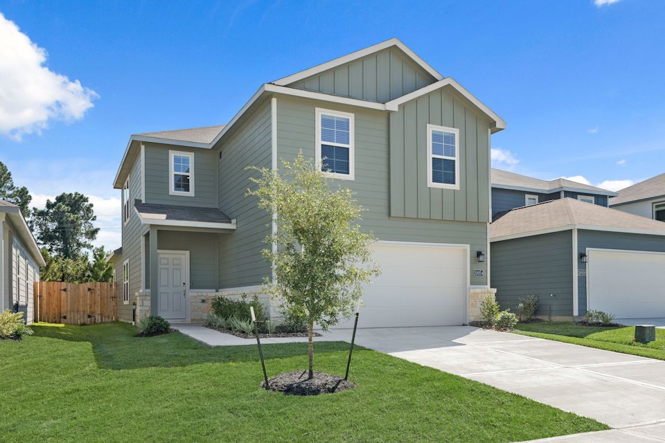 A house with a tree in the front yard.