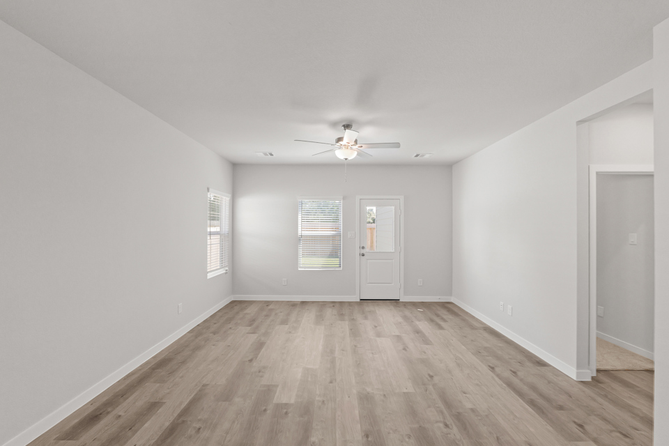 A room with a wood floor and a ceiling fan.