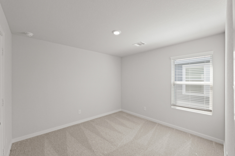 A room with a window and a rug.