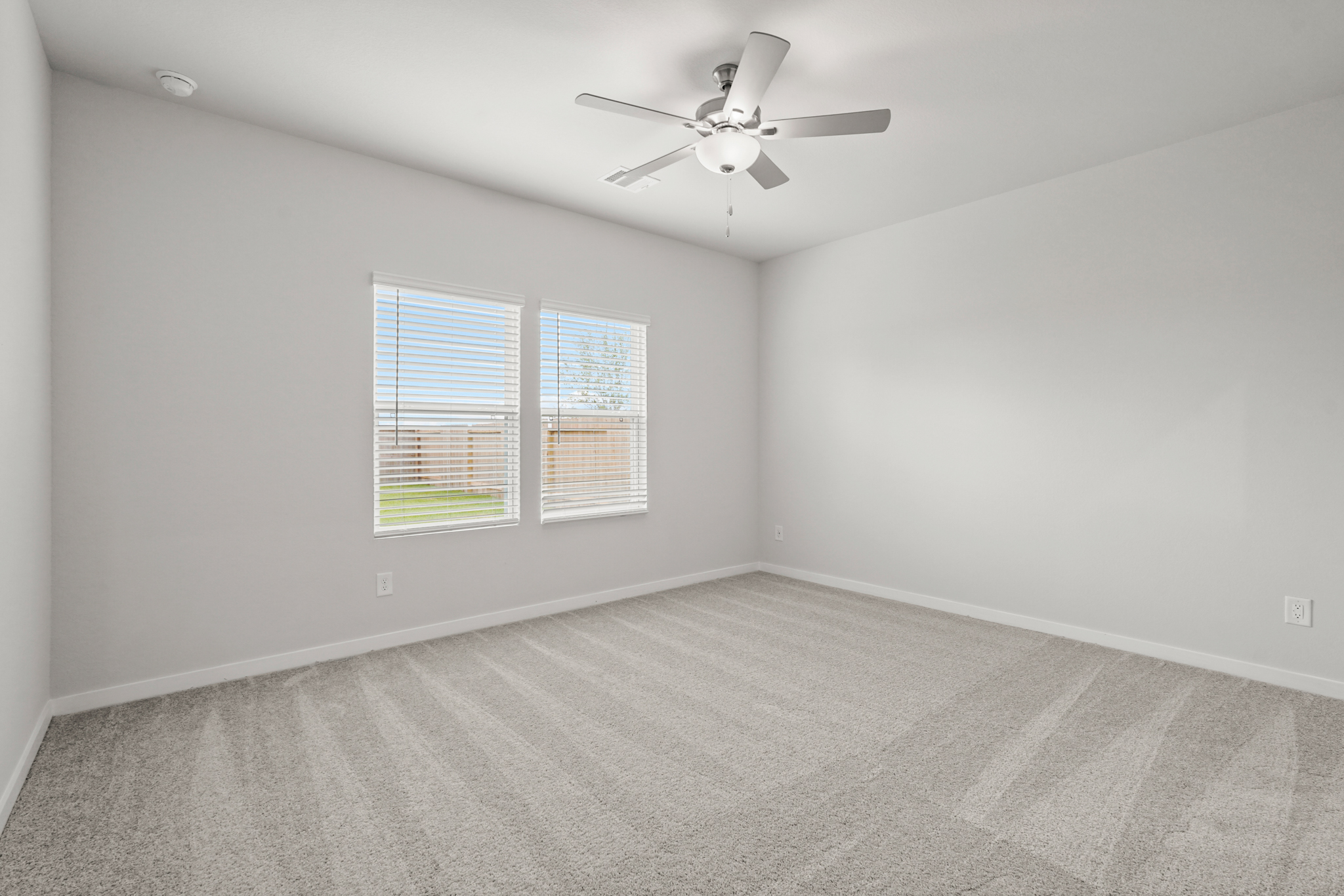 A room with a ceiling fan and a window.