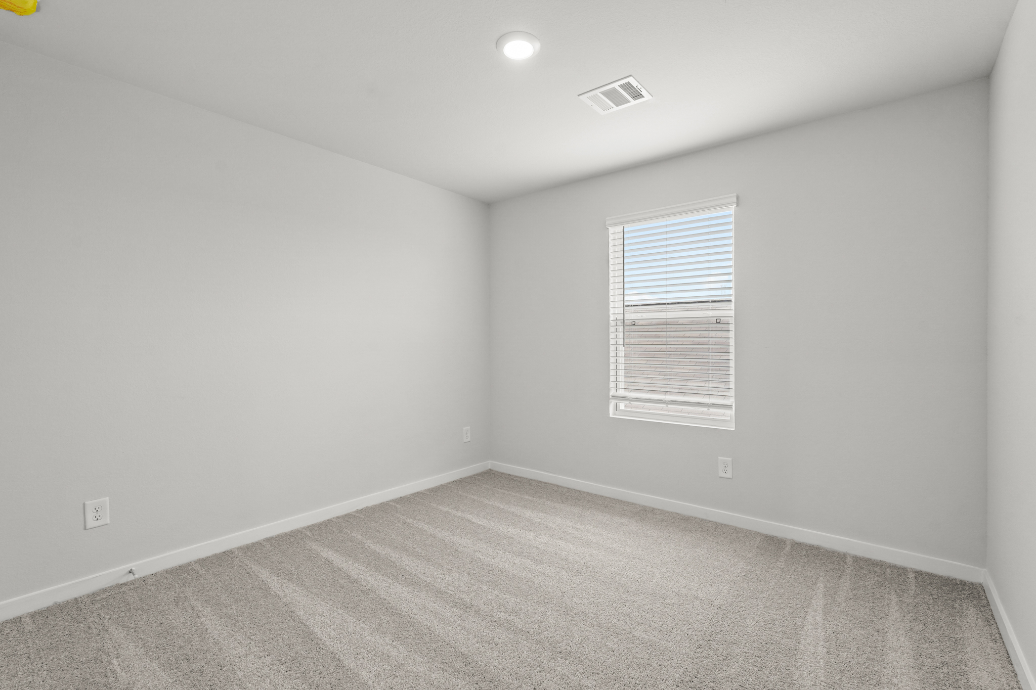 A room with a window and a carpet.