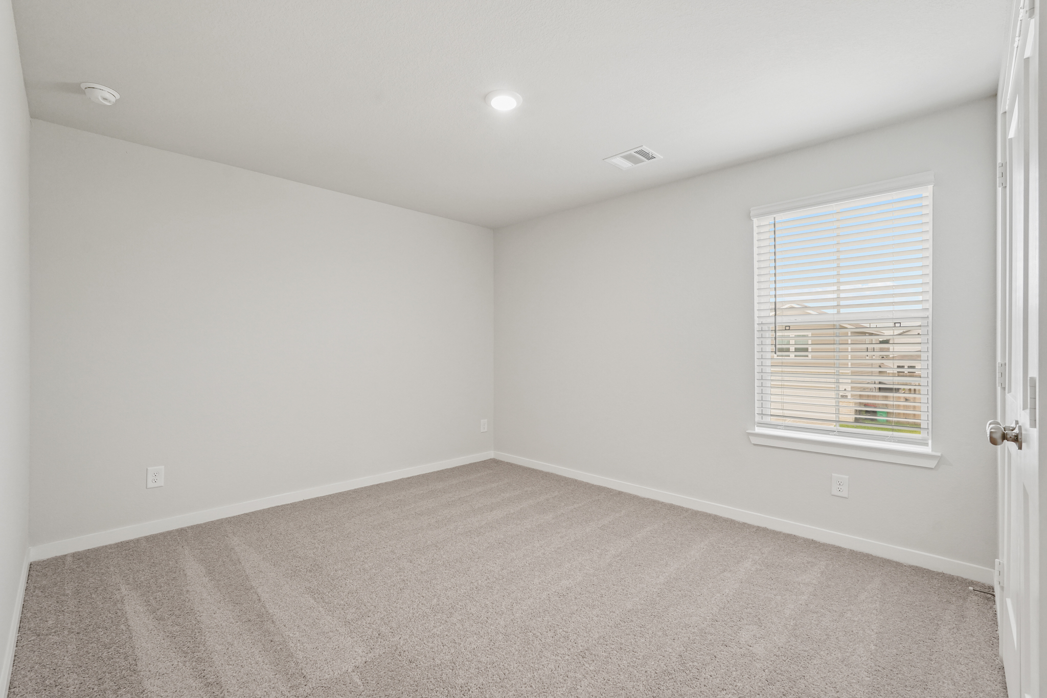 A room with a carpet and a window.