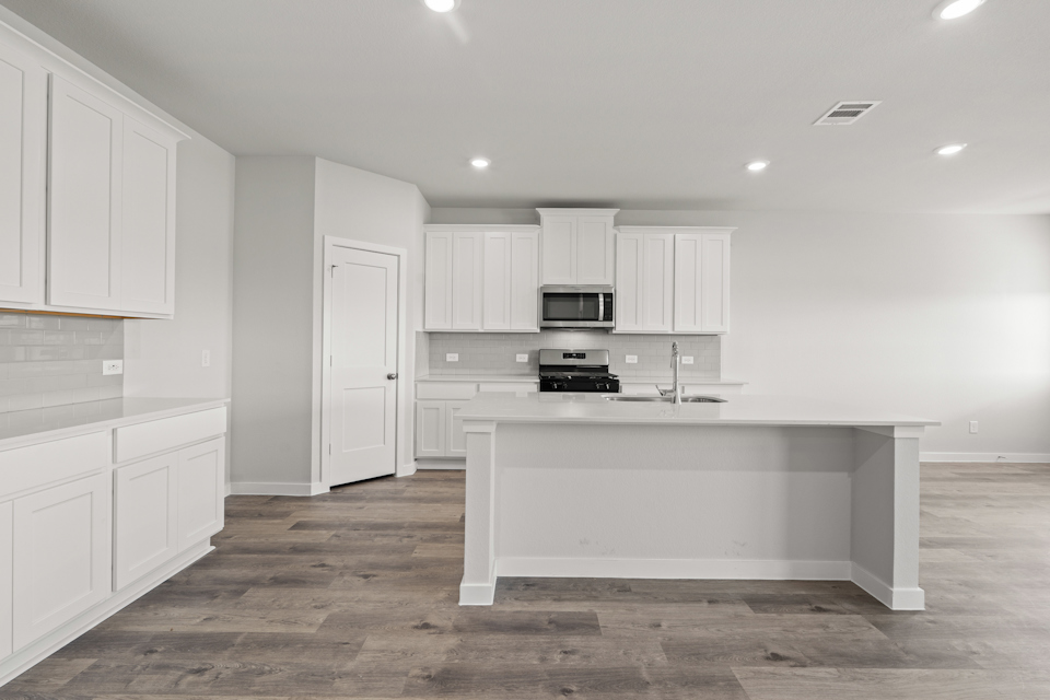 A kitchen with white cabinets.