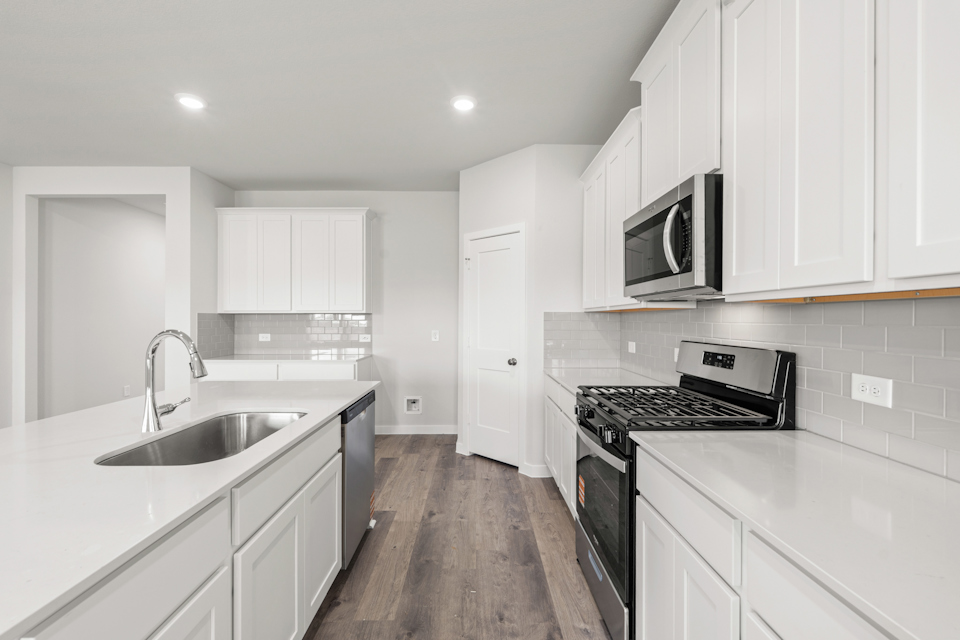A kitchen with white cabinets.