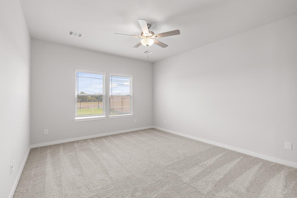 A room with a ceiling fan and a window.