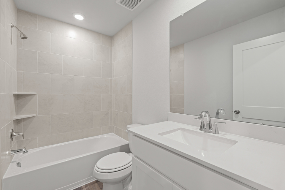 A bathroom with a tub sink and toilet.