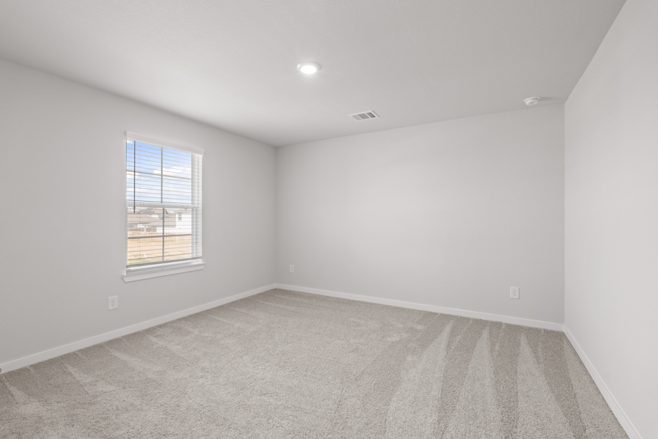 A room with a window and a carpet.