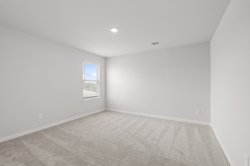A room with a carpet and a window.