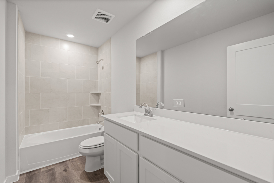 A bathroom with a tub toilet and sink.