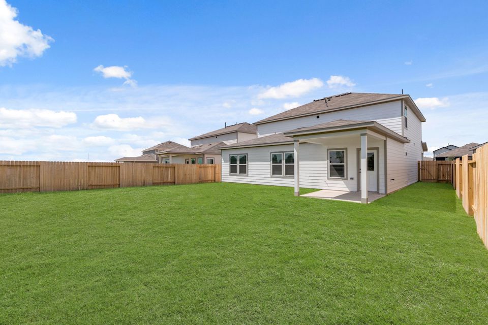 A house with a fence and grass.