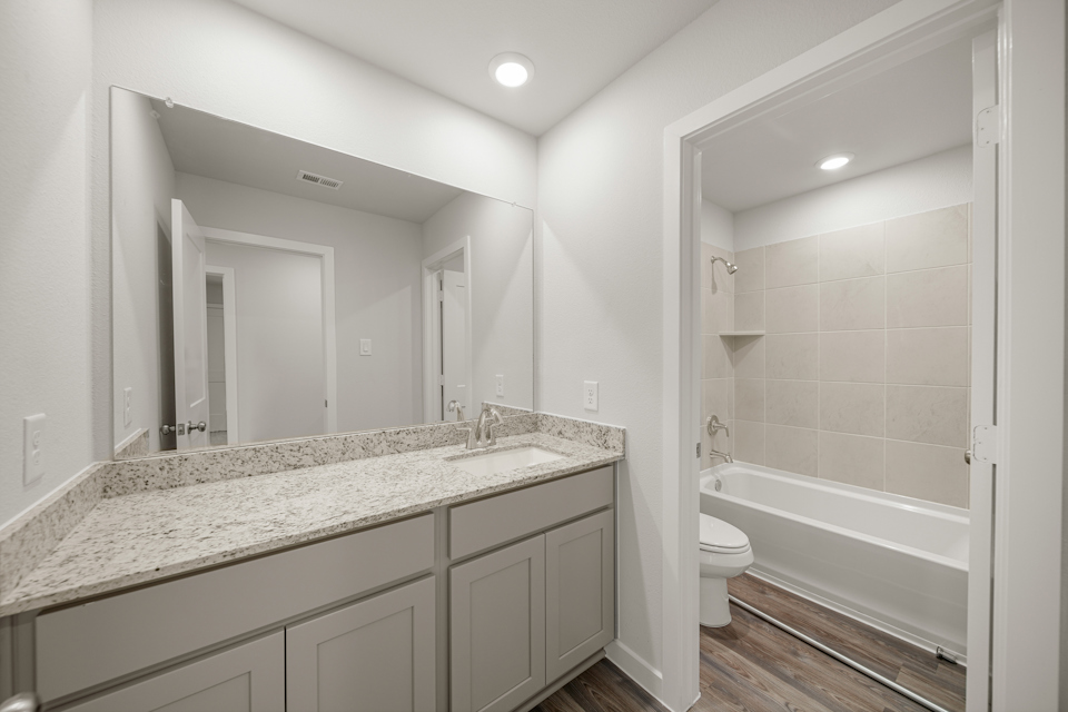 A bathroom with a tub sink and toilet.