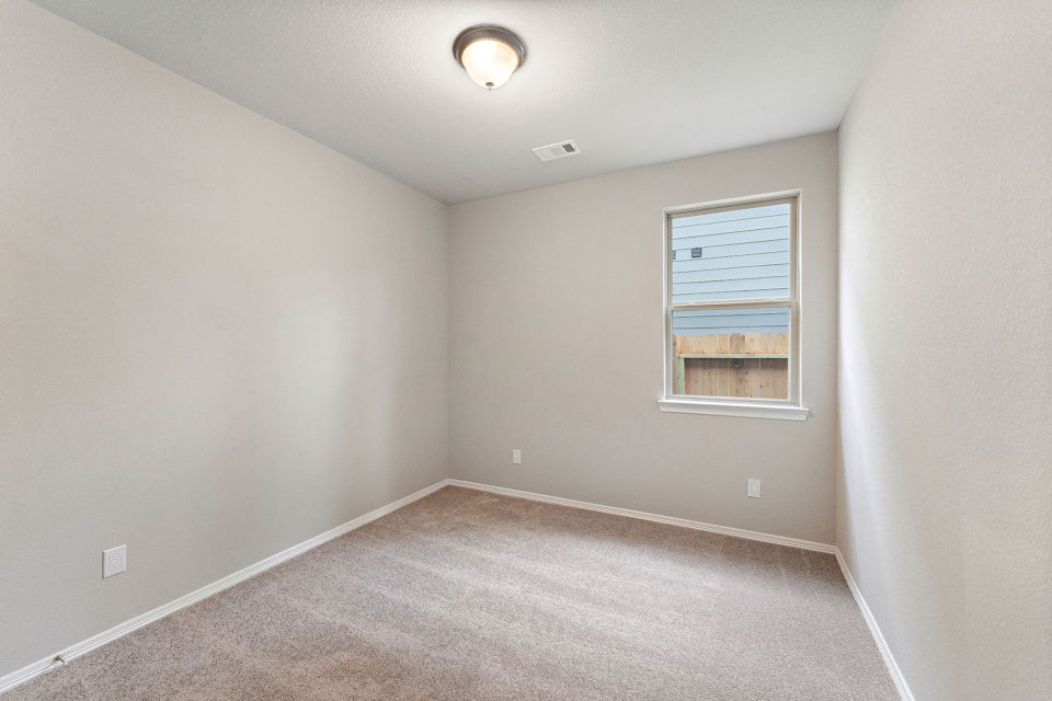 A room with a carpet and a window.