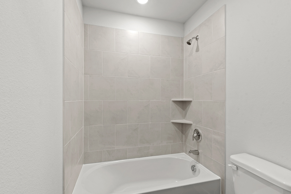A bathroom with a bathtub and toilet.