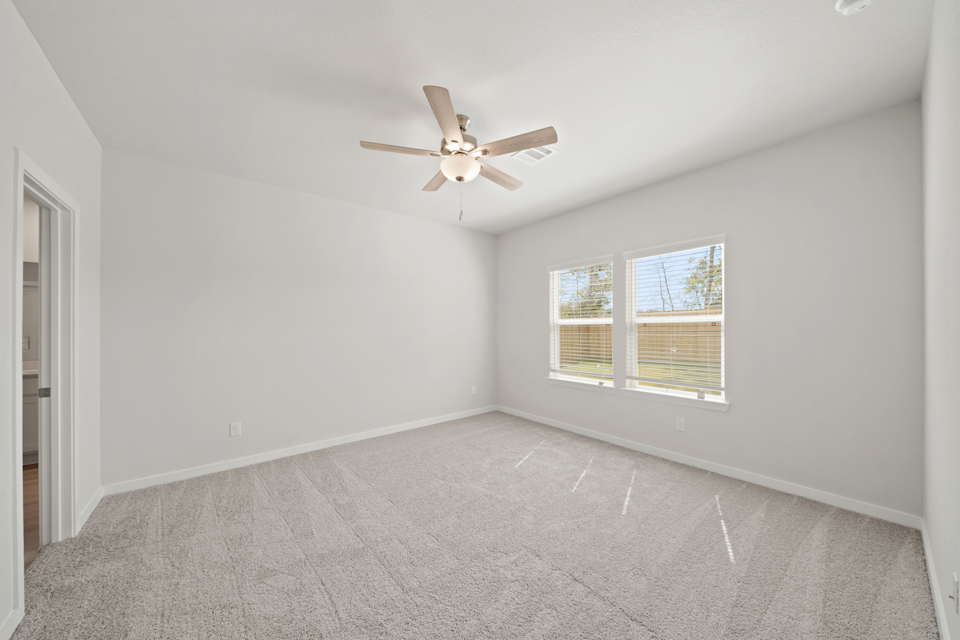 A room with a ceiling fan and a window.