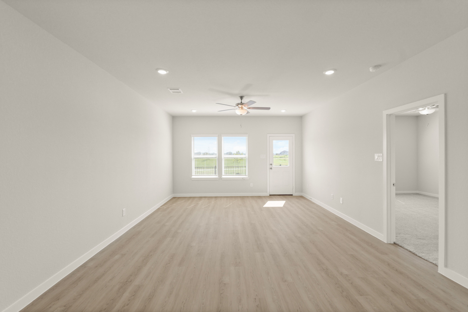 A room with a wood floor and a ceiling fan.